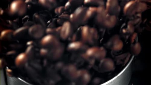 Kaffeebohnen in einer funktionierenden Mühle, gefilmt mit einer Hochgeschwindigkeitskamera mit 1000 Bildern pro Sekunde