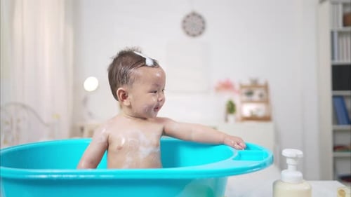 Adorable Baby Enjoying a Bath in Blue Tub