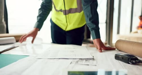 Hands of architect check blueprint at construction site for building, house