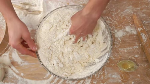 Hands Kneading Dough in Glass Bowl Close Up