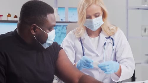 Man Receiving a Vaccine Shot in Hospital Office