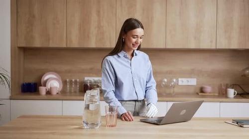 Woman Uses Laptop in Modern Kitchen