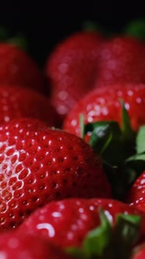 Fresh Ripe Strawberries on Black Background Showing Vibrant Color Vertical Video