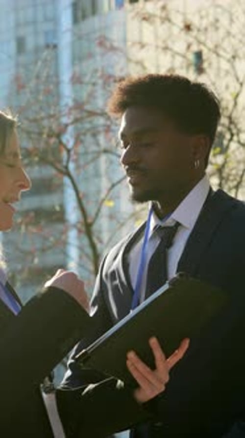 Diverse Business Colleagues Discussing Work on Tablet in City Park