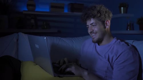 Young Adult Using Laptop at Home at Night