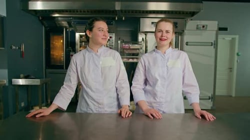 a team of smiling professional bakers in a professional kitchen in a bakery before the start baking