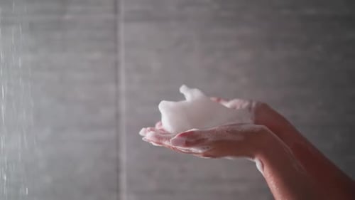 Hands Holding Soap in Shower Close-Up