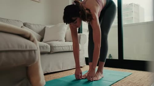 Woman Stretching on a Yoga Mat at Home