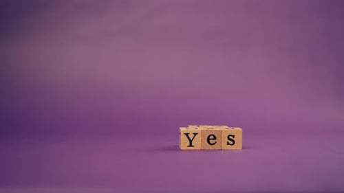 Wooden Blocks Spell "Yes" on Purple Background