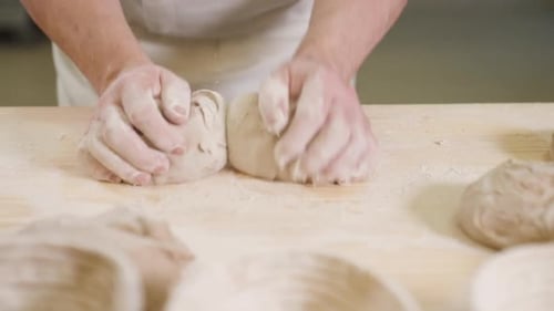Hands Kneading Dough on Wooden Table