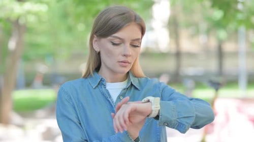 Young Woman Using Smartwatch Outdoor in Park