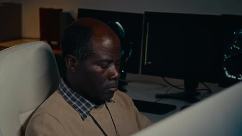 Man Working on Multiple Computers at Desk