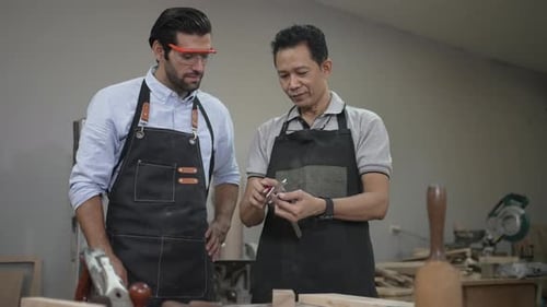 Carpenters are working together at workshop.