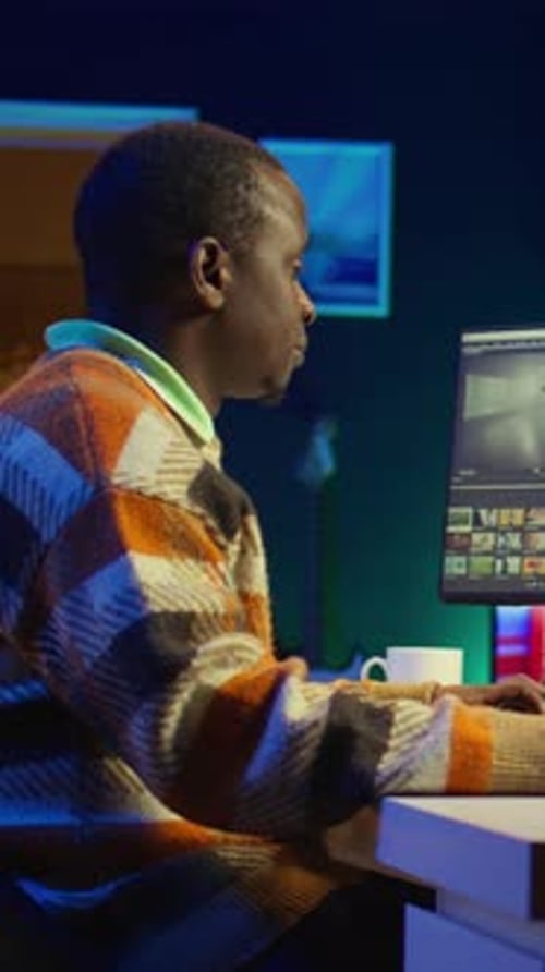 Adult Man Editing Video at Night on Computer