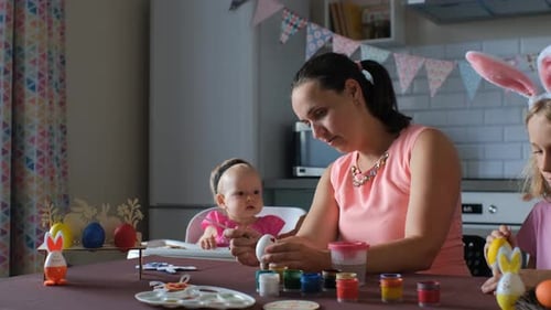 Family Decorating Easter Eggs at Home Together