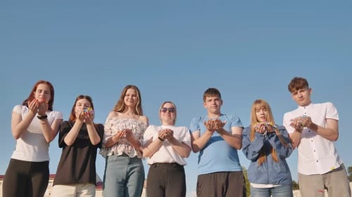 Friends Blow Colorful Paper Confetti on a Sunny Day