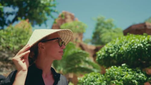 Woman in Traditional Hat in Tropical Setting