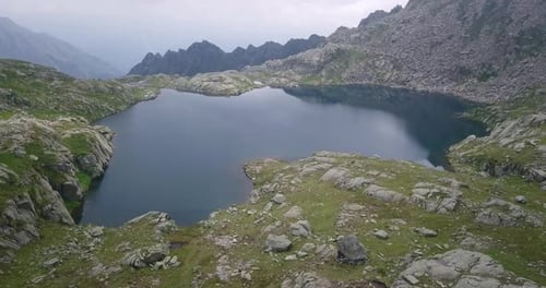 Aerial shot of an lake of mountains surrounded by nature in a magical, relaxing and green place.