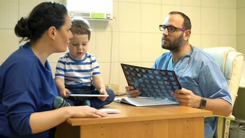Doctor explains good scan results to happy mother and child in hospital office