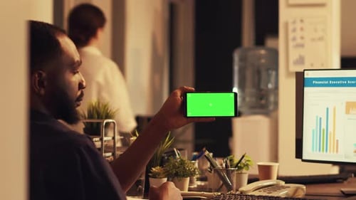 Man Using Green Screen Phone in Modern Office