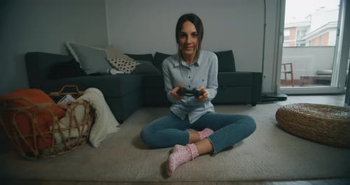Zeitlupe einer jungen Frau macht es Spaß, abends im Wohnzimmer ein Videospiel zu spielen.