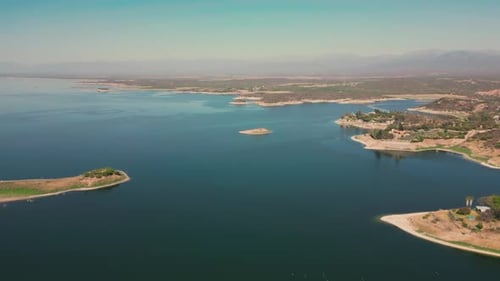 Aerial drone flying over a lake, water dam, with mountains at sunrise. Beautifull dreamy landscape v