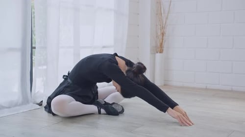 Young Woman Stretches Before Ballet Practice