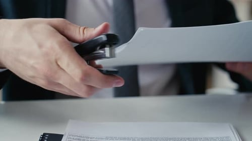 Man Using a Stapler at Office Workplace