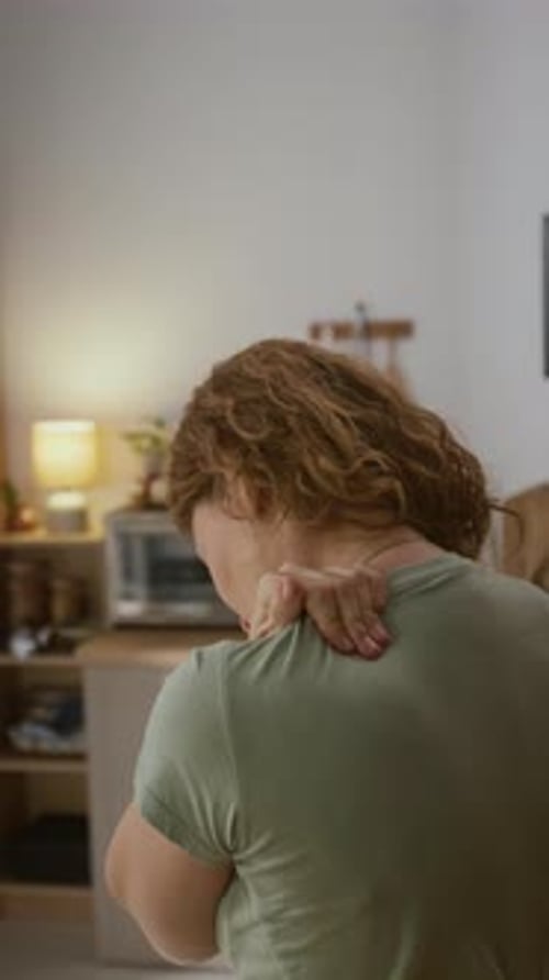 Woman Massaging Shoulder and Neck Indoors For Relief