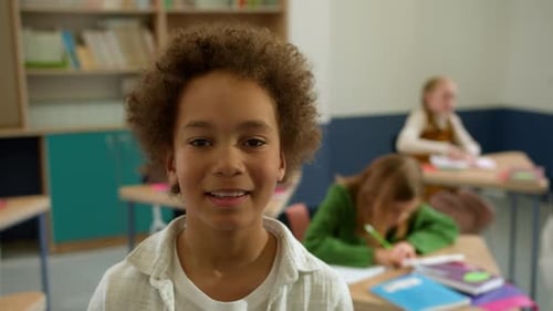 Elementary School Class Children Communicate with the Teacher Answering Question
