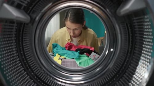 View From Inside the Washing Machine Young Woman Holding a Bottle of Fabric Softener and Washing