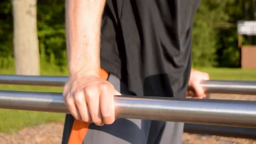 Junger weißer Mann führt Dips-Übung durch