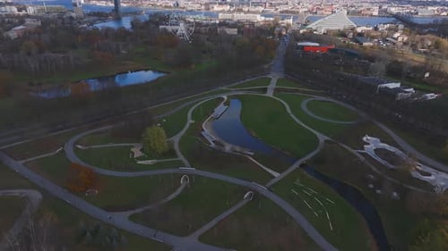 Vista aérea do Victory Park em Riga, com caminhos, rio e parque de skate
