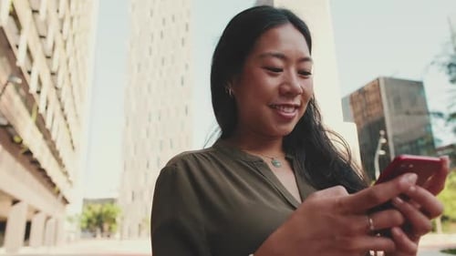 Close-up of young happy businesswoman using mobile phone