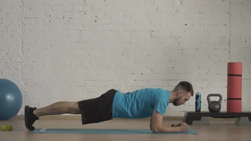 Young Adult Male Planking in Fitness Studio