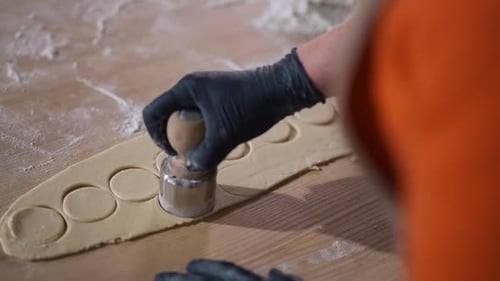 High Angle View Closeup Unrecognizable Woman Cutting Round Pieces with Dough Cutter on Wooden