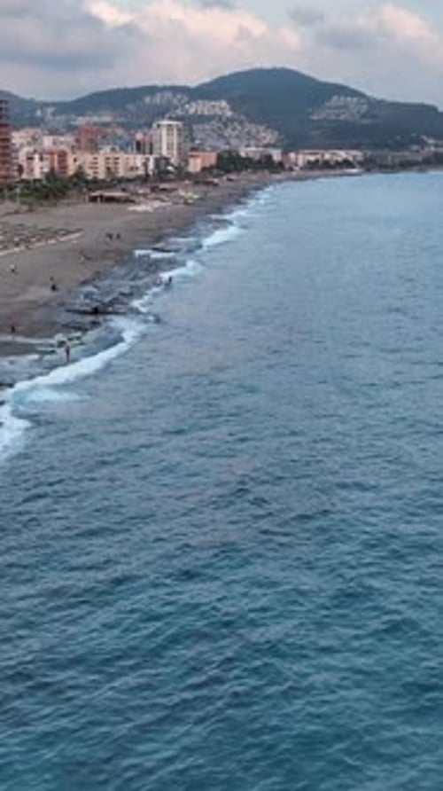 Vertical Video Seaside Twilight Gathering Mediterranean Evening Fun in the Water and on the Shore