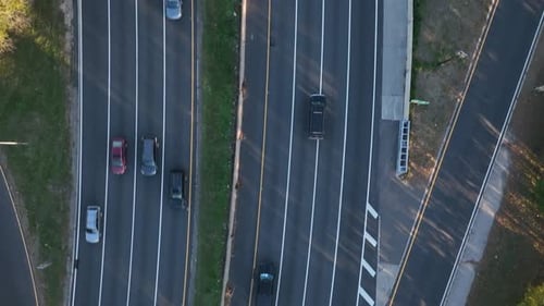 A high angle, top down view over a highway in slow-motion. The drone camera tilted straight down, do