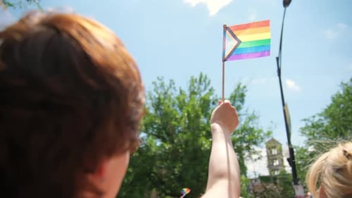 People Waving Pride Flag at a Pride Parade