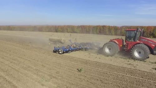 Big red combine working on the field cultivating and applying nitrogen ASP