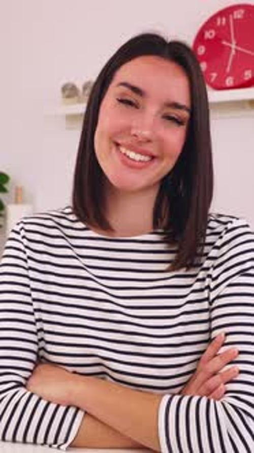 Portrait of Young Happy Woman Smiling at the Camera Sitting at Kitchen Table