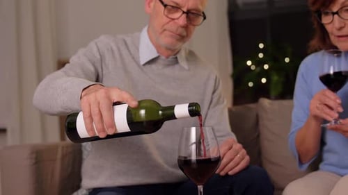 Senior Couple Pouring Wine in Cozy Living Room