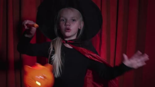 Girl dressed as witch with pumpkin decoration