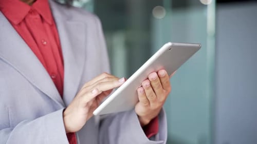 Close up of female hands holding using digital tablet in business office. Businesswoman
