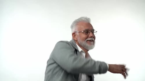 Expressive Senior Man Dancing Against White Background