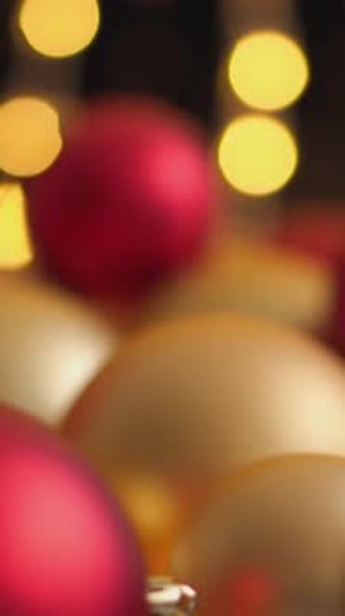 Red and Gold Christmas Ornaments are Arranged in a Festive Display with Glowing Bokeh Lights in the