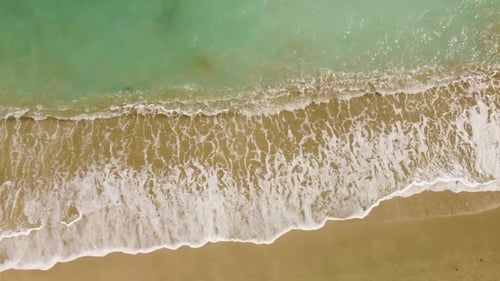 Fantastische Luftaufnahme von Sandstrand und weißen Wellen mit Haube