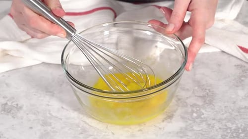 Whisking Eggs and Adding Flour in Glass Bowl