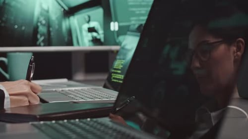 Female Cybersecurity Specialist Working in Dark Office