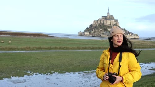 tourist woman walks with her camera through the saint michel valley photographing monuments